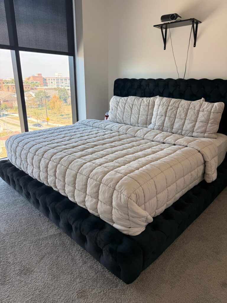 Freshly made king bed with a Houston city view after an Airbnb turnover cleaning in Houston