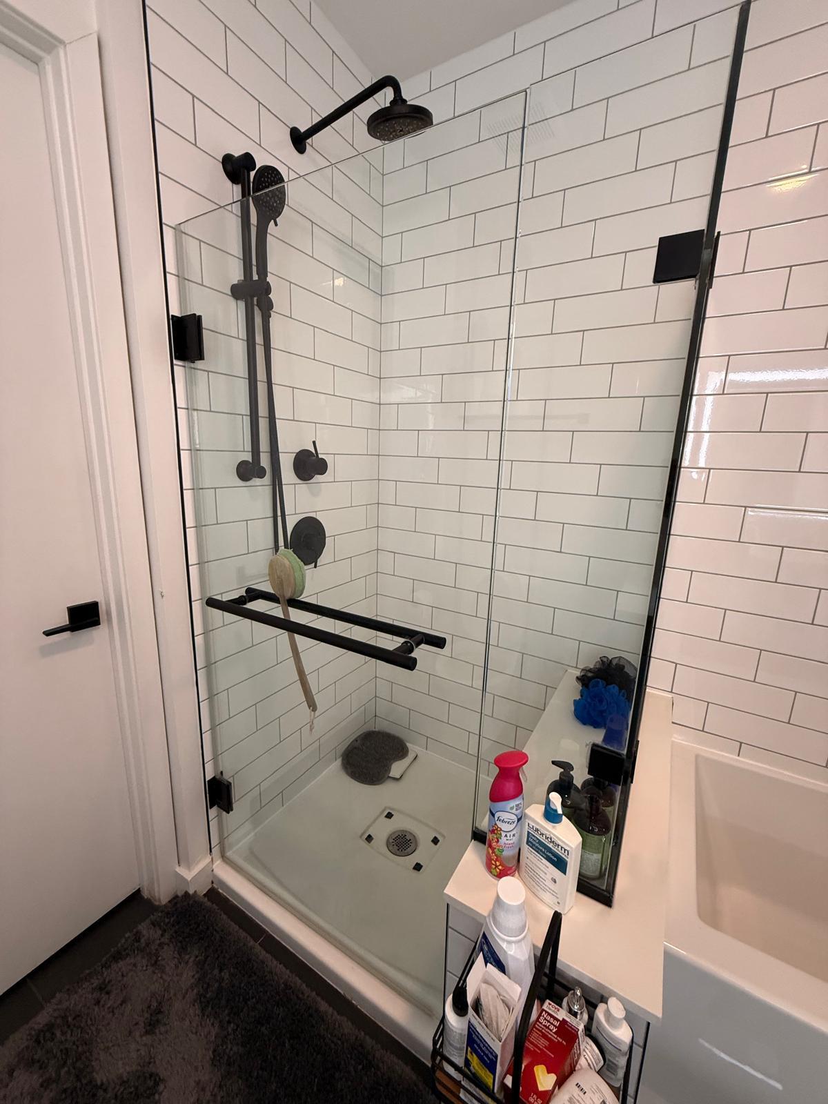 Sparkling glass shower and white tile wiped down during an Airbnb turnover cleaning in Houston